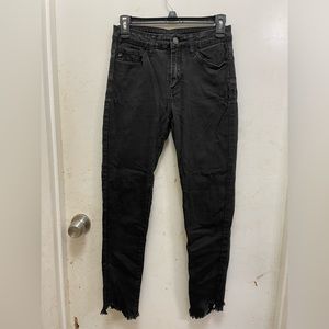 black jeans with fringe at bottoms, looks like it’s cut